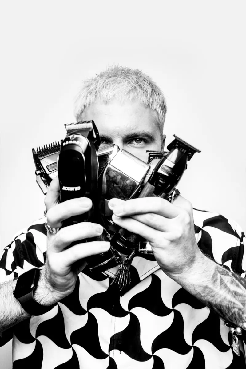 Hairdresser photoshoot — barber clippers held toward the camera in monochrome