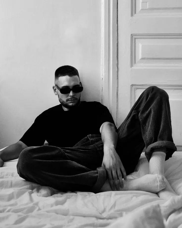 A black tee on a sofa in black and white — men's portrait