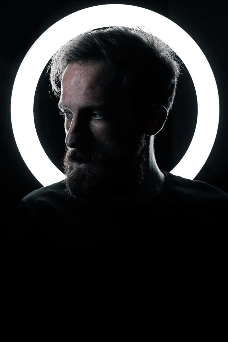 A male silhouette framed by a ring light