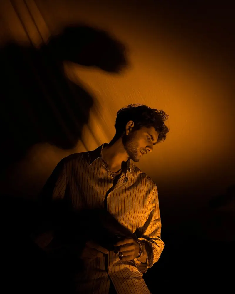 A male profile in deep warm shadow