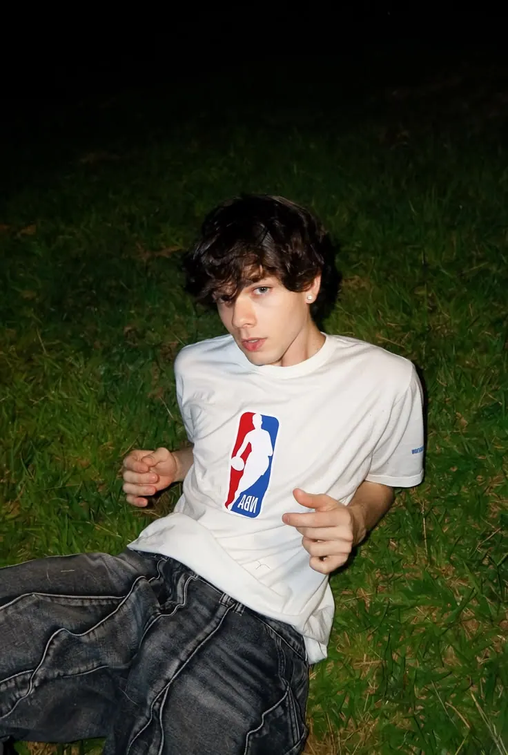 A white sports tee while sitting on grass — men's portrait