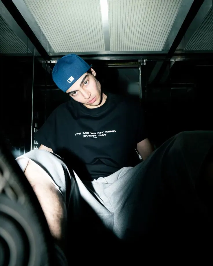 A blue cap inside a metal lift — men's portrait