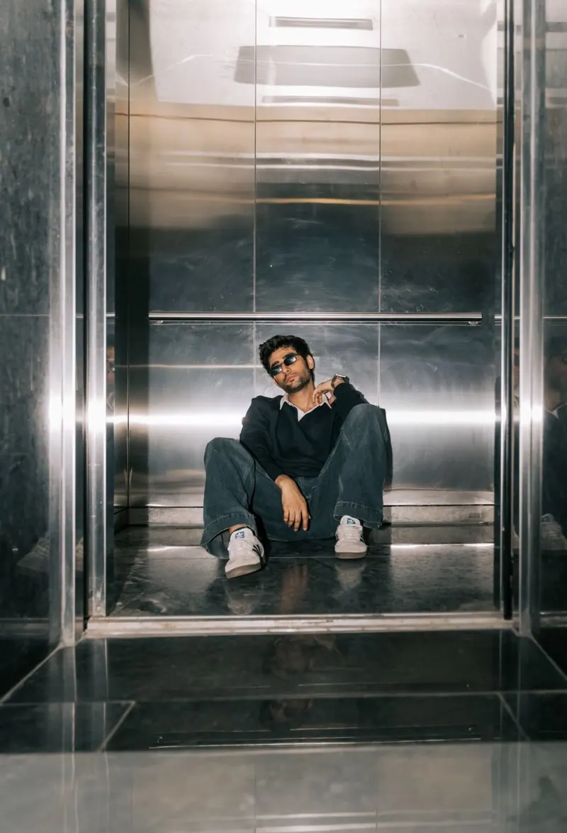 A man seated on the floor of a metal lift
