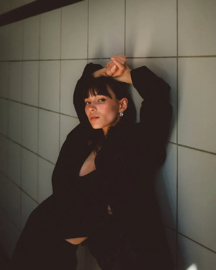 A black suit beside a tiled wall — women's portrait