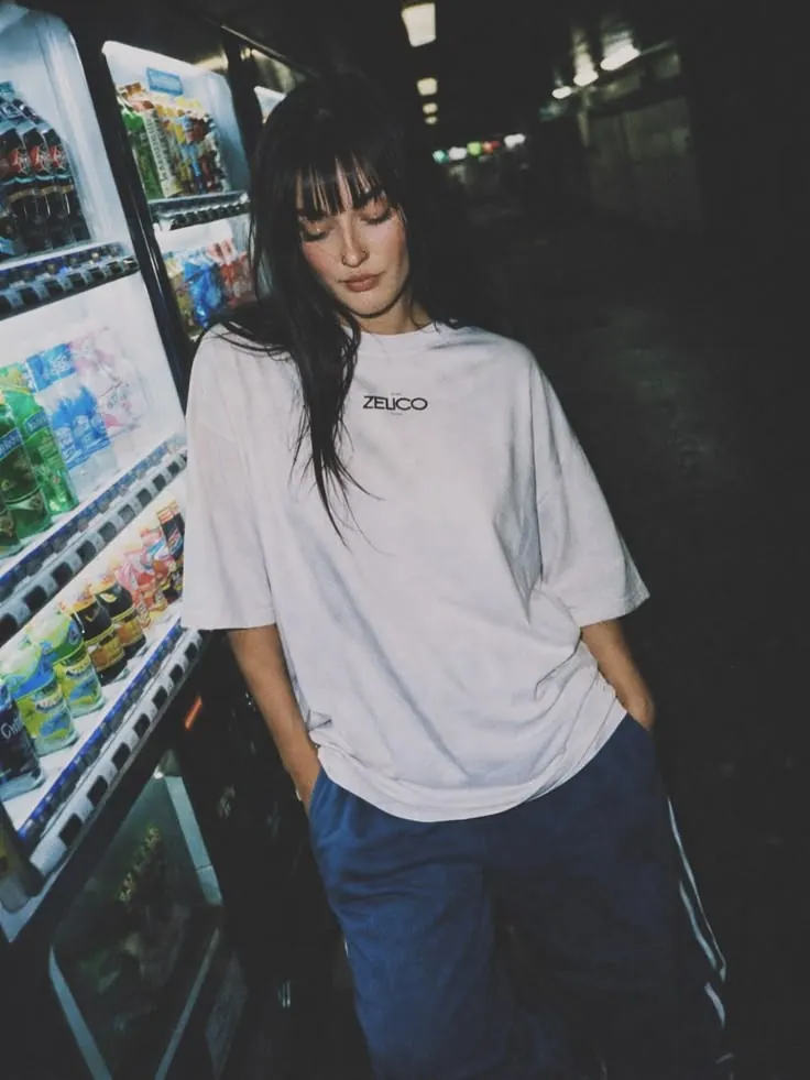 A white tee beside a vending machine — women's portrait