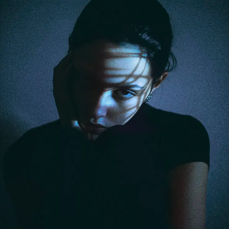Striped shadows in blue light — women's portrait