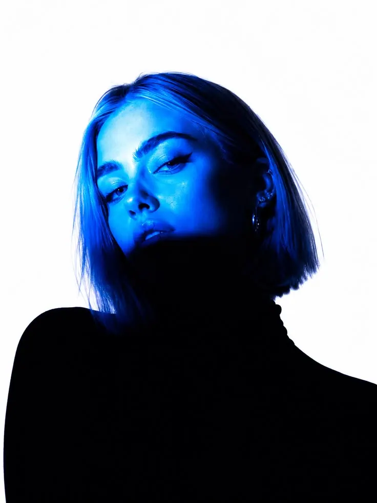A bob outlined by blue rim light — women's portrait