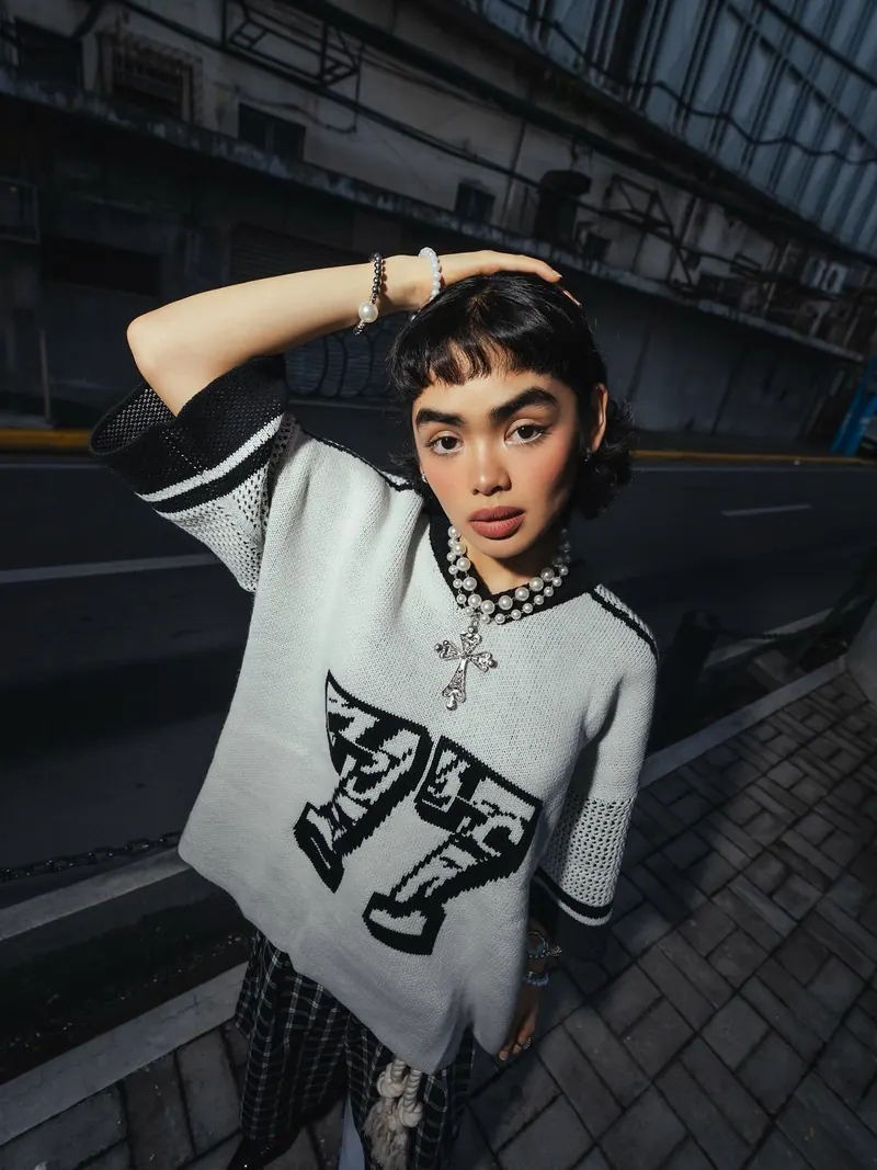 Chains and a graphic jumper in the city — women's portrait