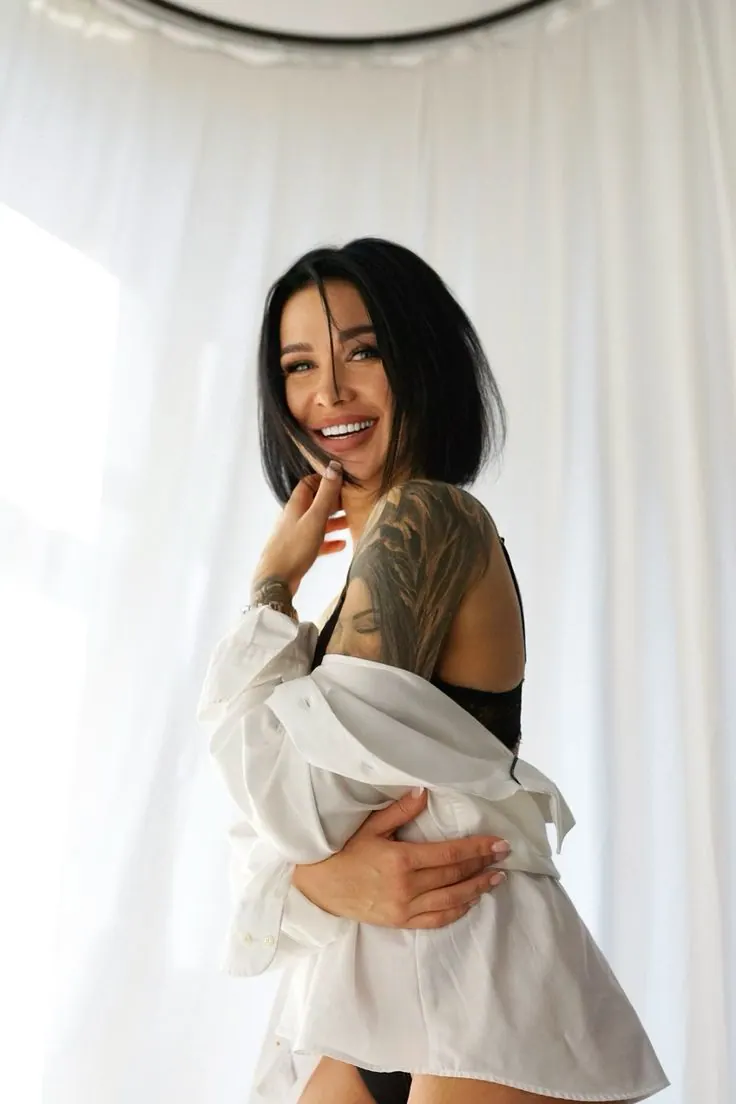 Camisa blanca y una risa junto a la ventana — retrato de mujer