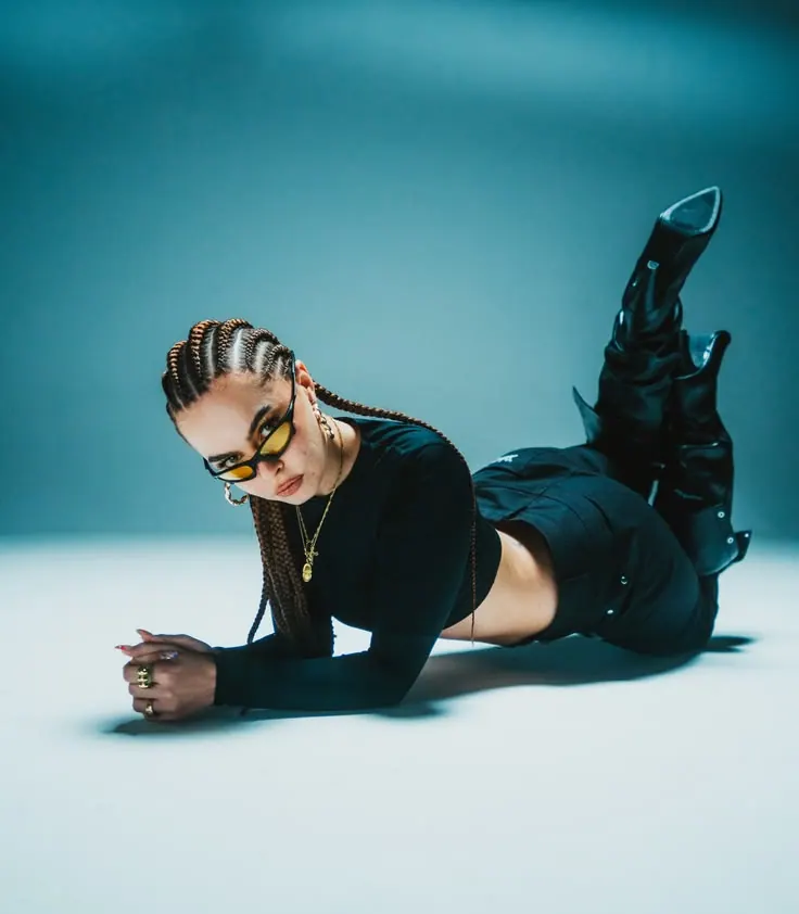 Braids and a black look on a cyan floor — women's portrait