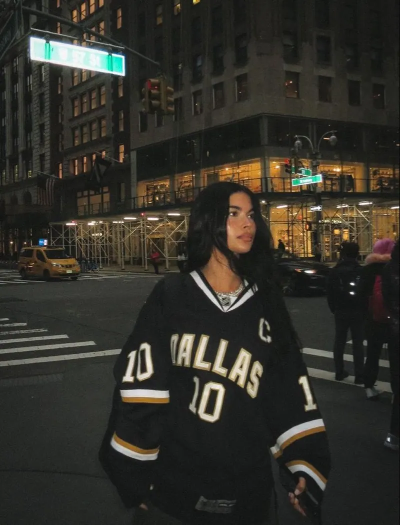 An oversized sports jersey in the city at night — women's portrait