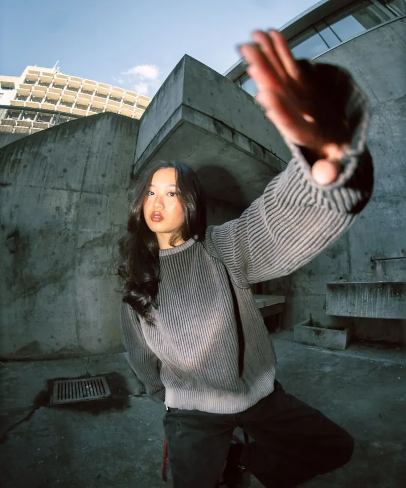 A hand by the lens and concrete — women's portrait