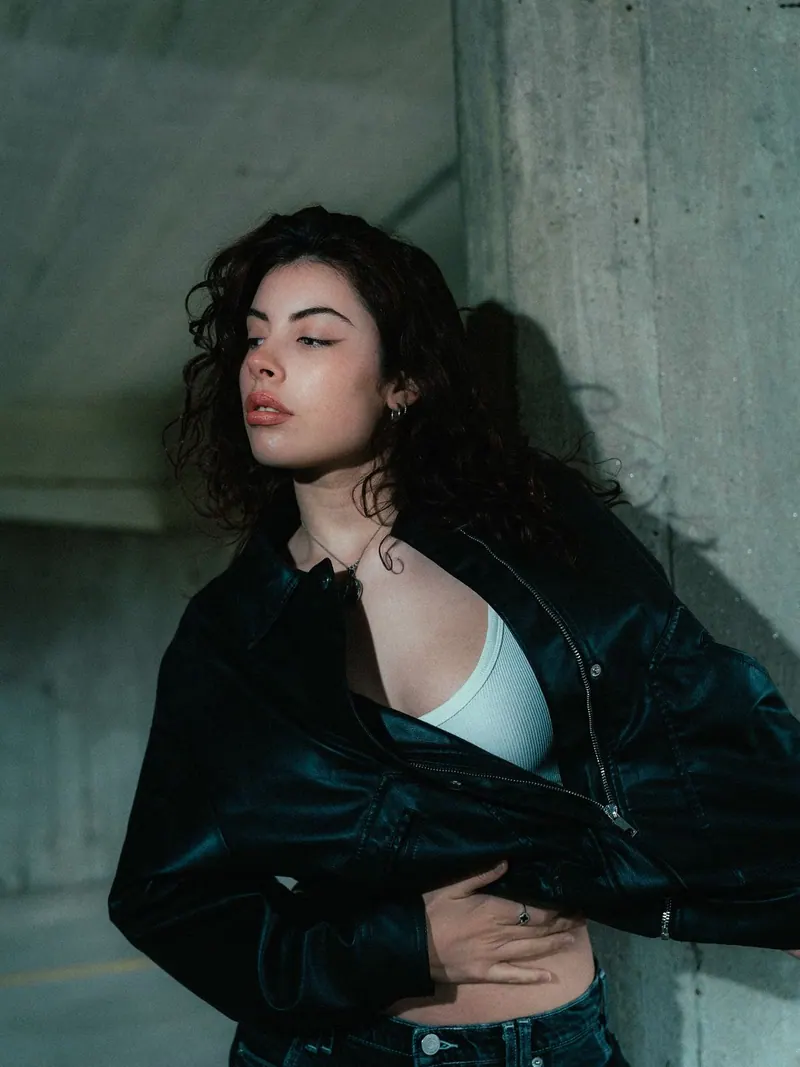 A black leather jacket by a concrete wall — women's portrait