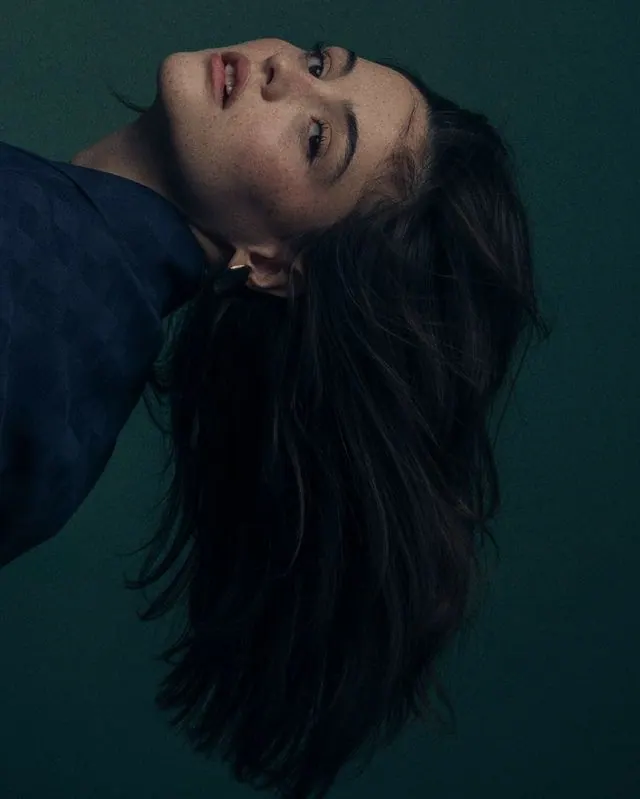 A reclining portrait in dark teal light — women's portrait