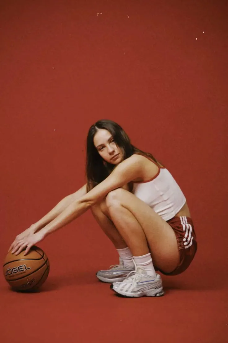 A basketball and sportswear against red — women's portrait