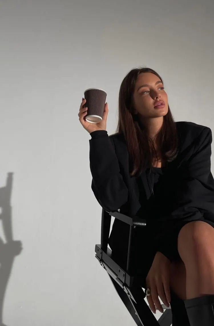 A takeaway coffee in a black director chair — women's portrait