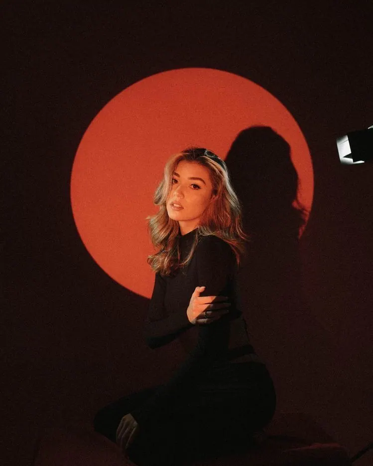 A red circular light in a dark studio — women's portrait