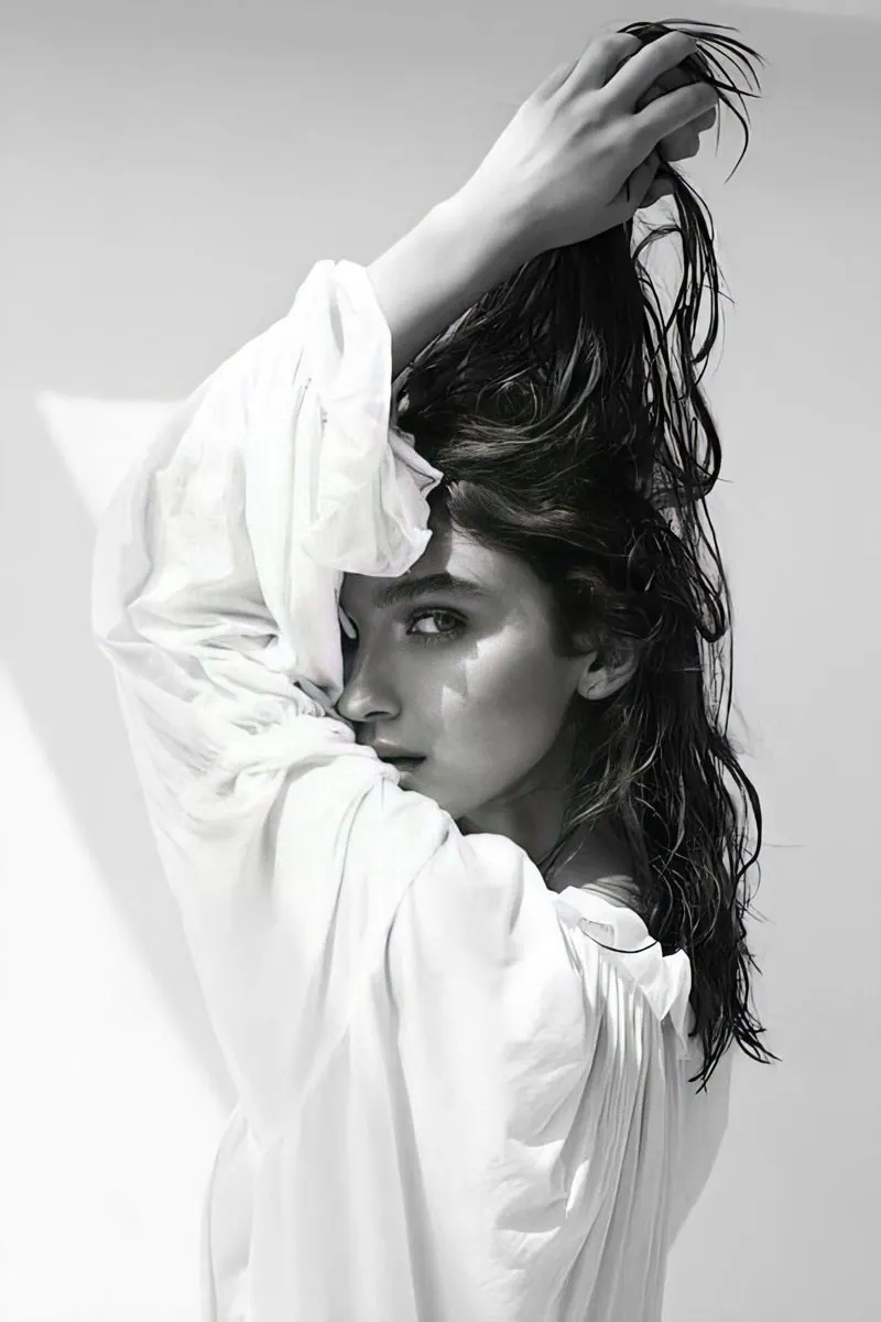 Hair lifted above a white shirt in monochrome — women's portrait