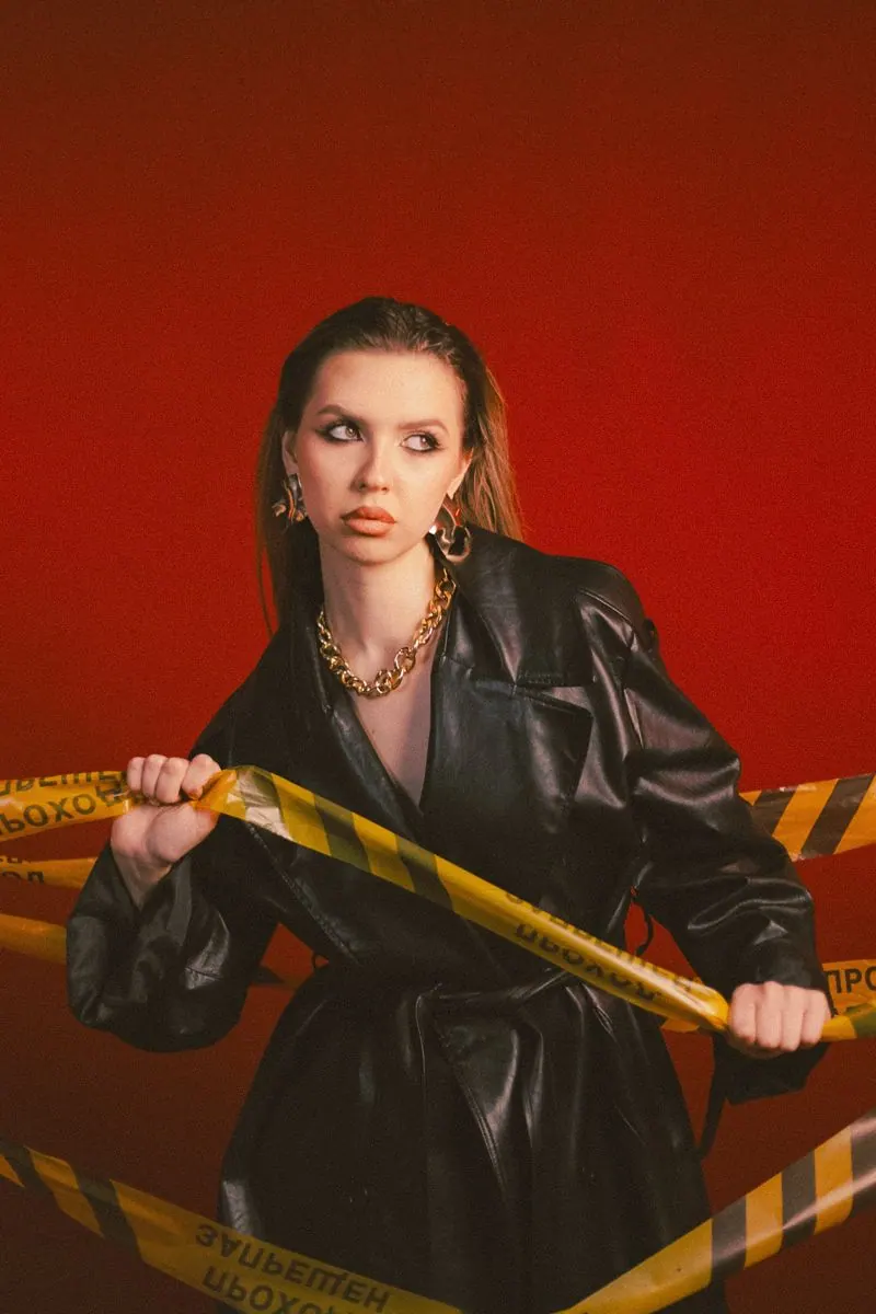 A leather jacket and yellow tape against red — women's portrait