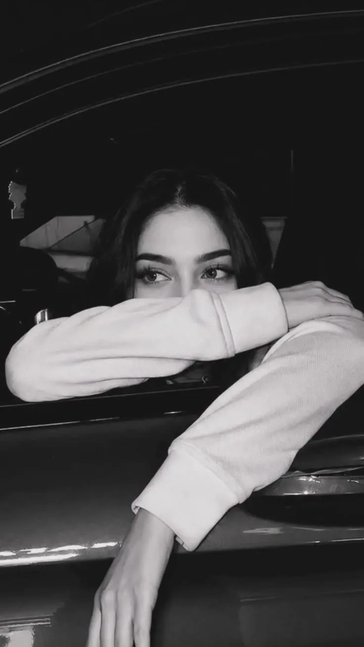 A black and white portrait through a car window — women's portrait
