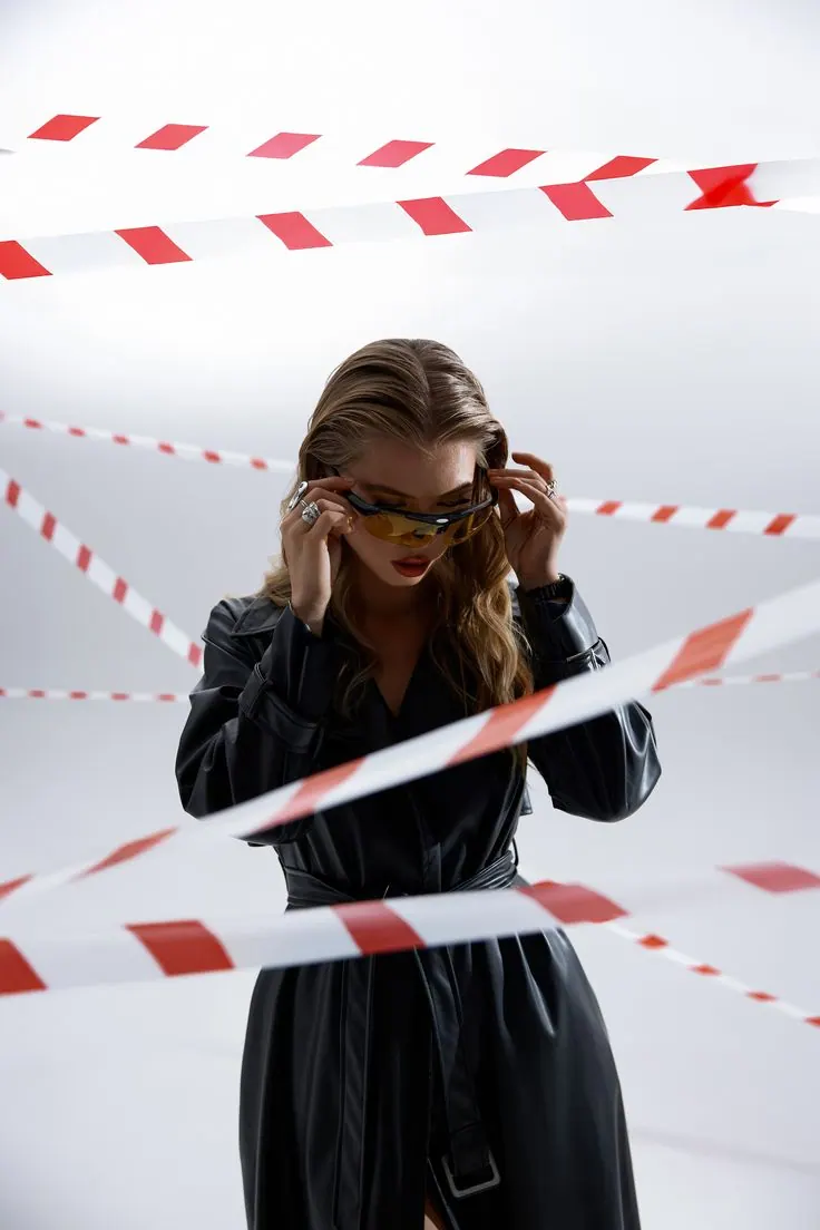 Red and white barrier tape across a bright portrait — women's portrait