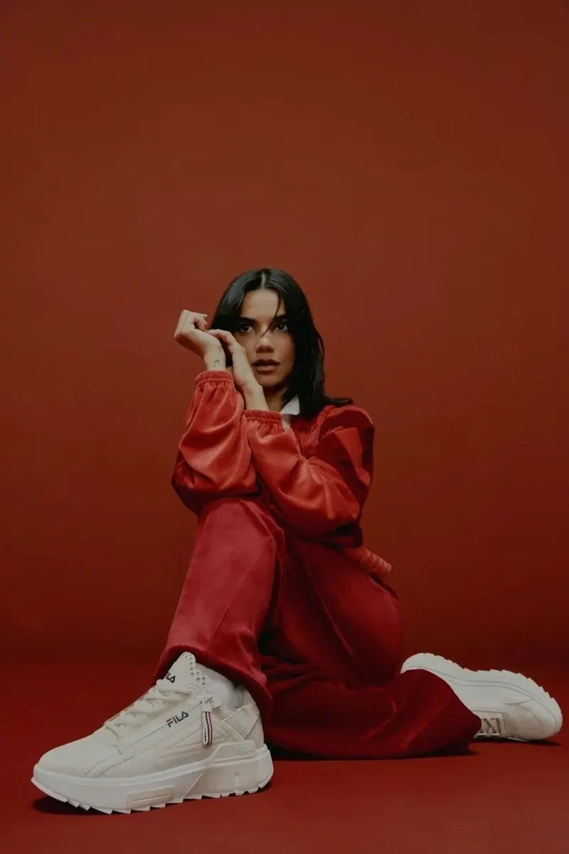 A red tracksuit against a red studio backdrop — women's portrait