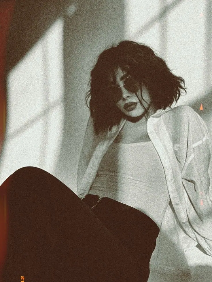 Una blusa blanca atravesada por sombras de ventana — retrato de mujer