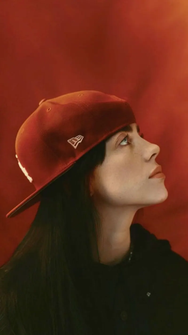 A red cap in profile against a warm backdrop — women's portrait