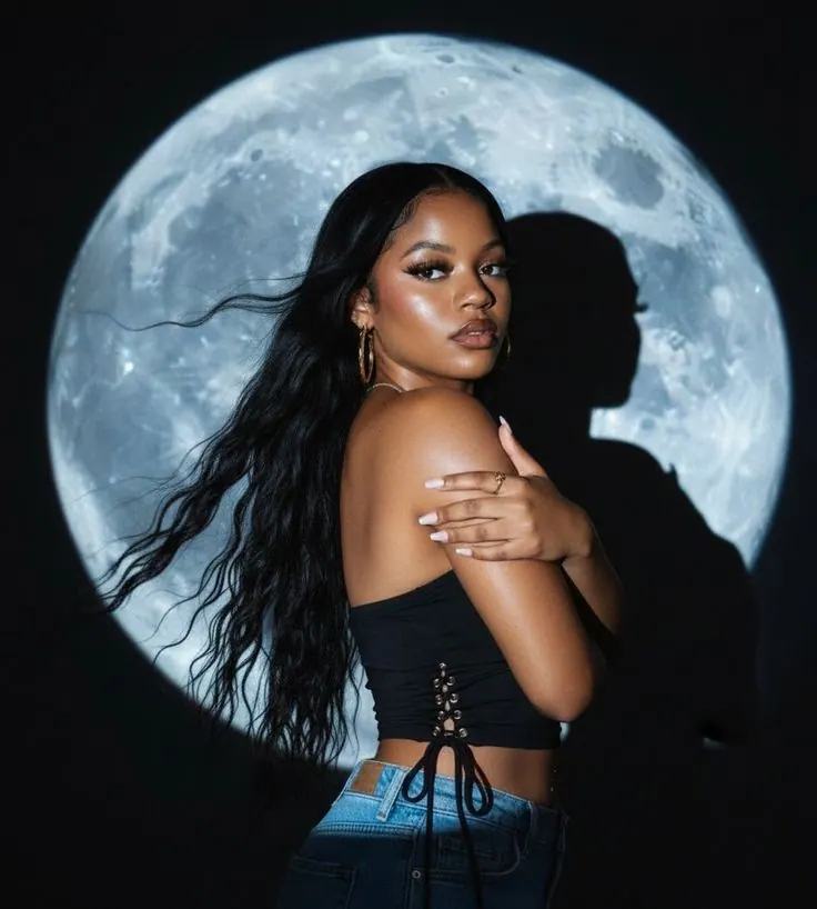 A woman in front of a large moon and blue sky