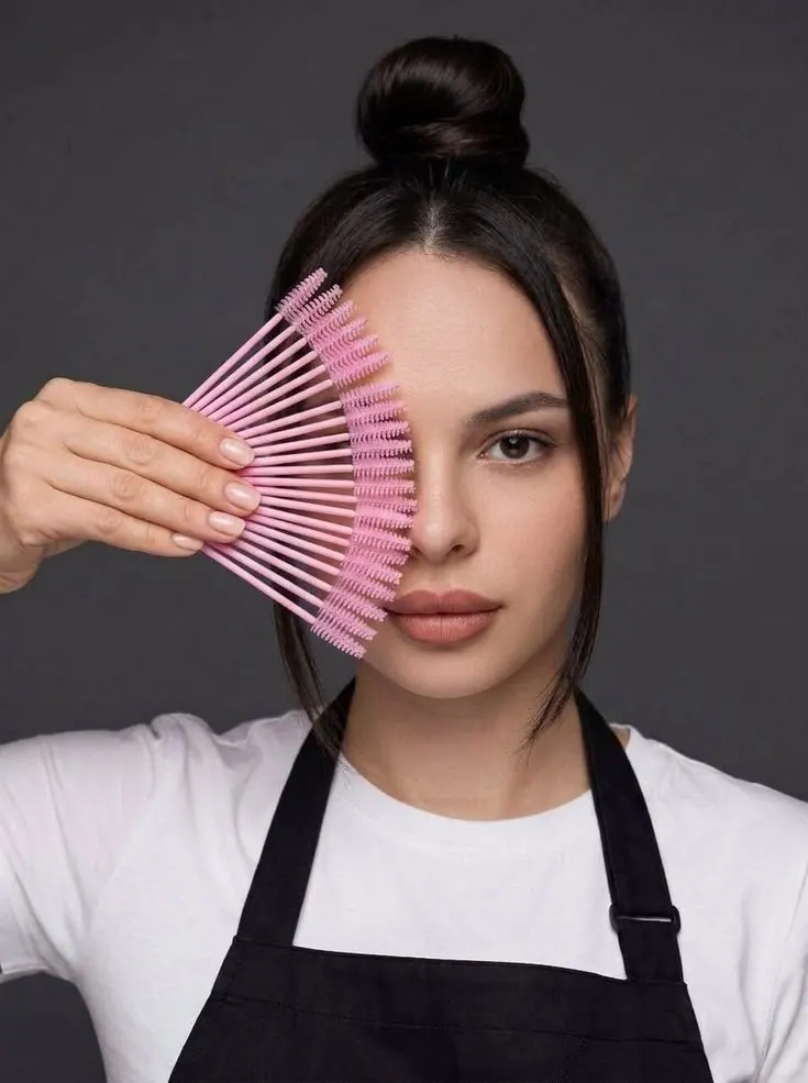 Hairdresser photoshoot — a hairdresser holding a pink comb beside her face